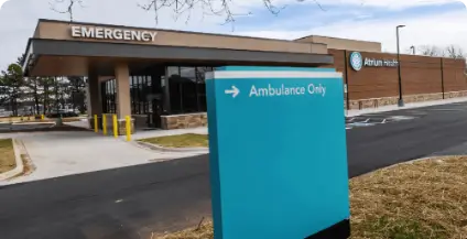 Exterior of Atrium Health's emergency entrance with a blue sign indicating 