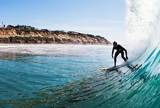 man surfing under big wave of the sea
