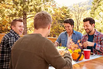 four men eating at an outdoor table