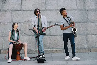 three people playing instruments on the street