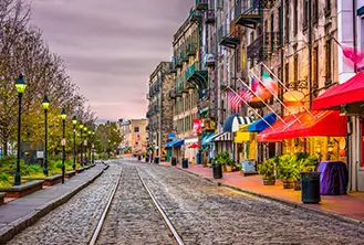 stone street with tram lanes amidst lit lamps and colorful buildings