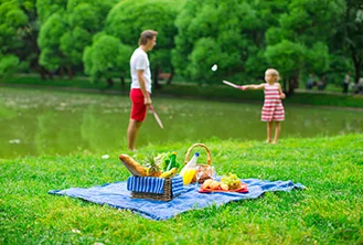 photograph of a picnic with a girl with her father playing