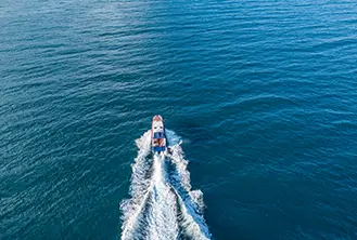 photo of a boat leaving a trail in the water
