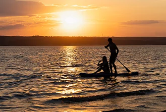 couple sailing in a canoe under a sunset