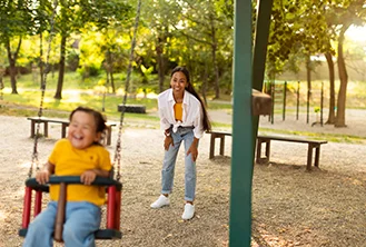 mother pushing her son on the swing