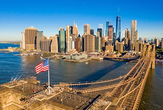 image of a bridge with the american flag leading to a city surrounded by water
