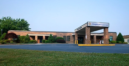 A one-story, brick healthcare facility with a prominent covered entrance and landscaped surroundings, conveying a welcoming and professional atmosphere.