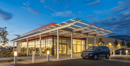 image of building in the afternoon, with cars parked next to it
