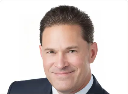 Headshot of Michael Dolister, smiling, wearing a black blazer and a white button-down shirt.