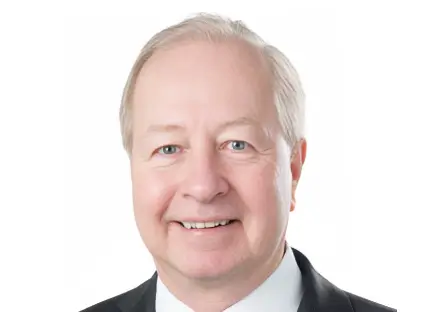 Headshot of Vincent Hoellerich, smiling, wearing a black blazer and a white button-down shirt.