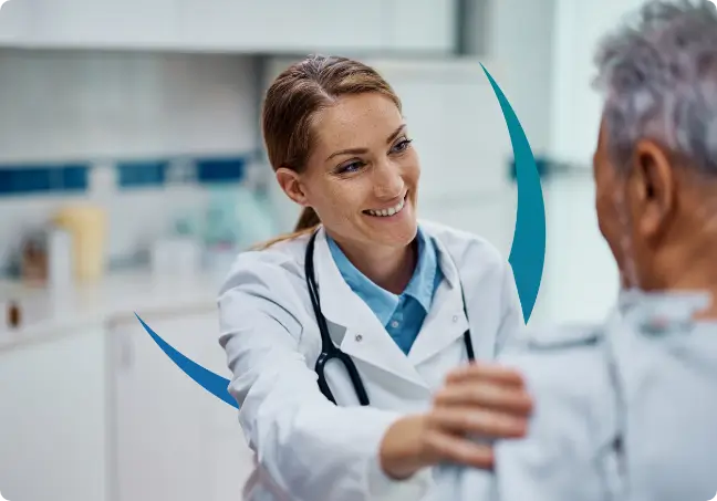 A medical professional smiling, she has a hand on a patients shoulder