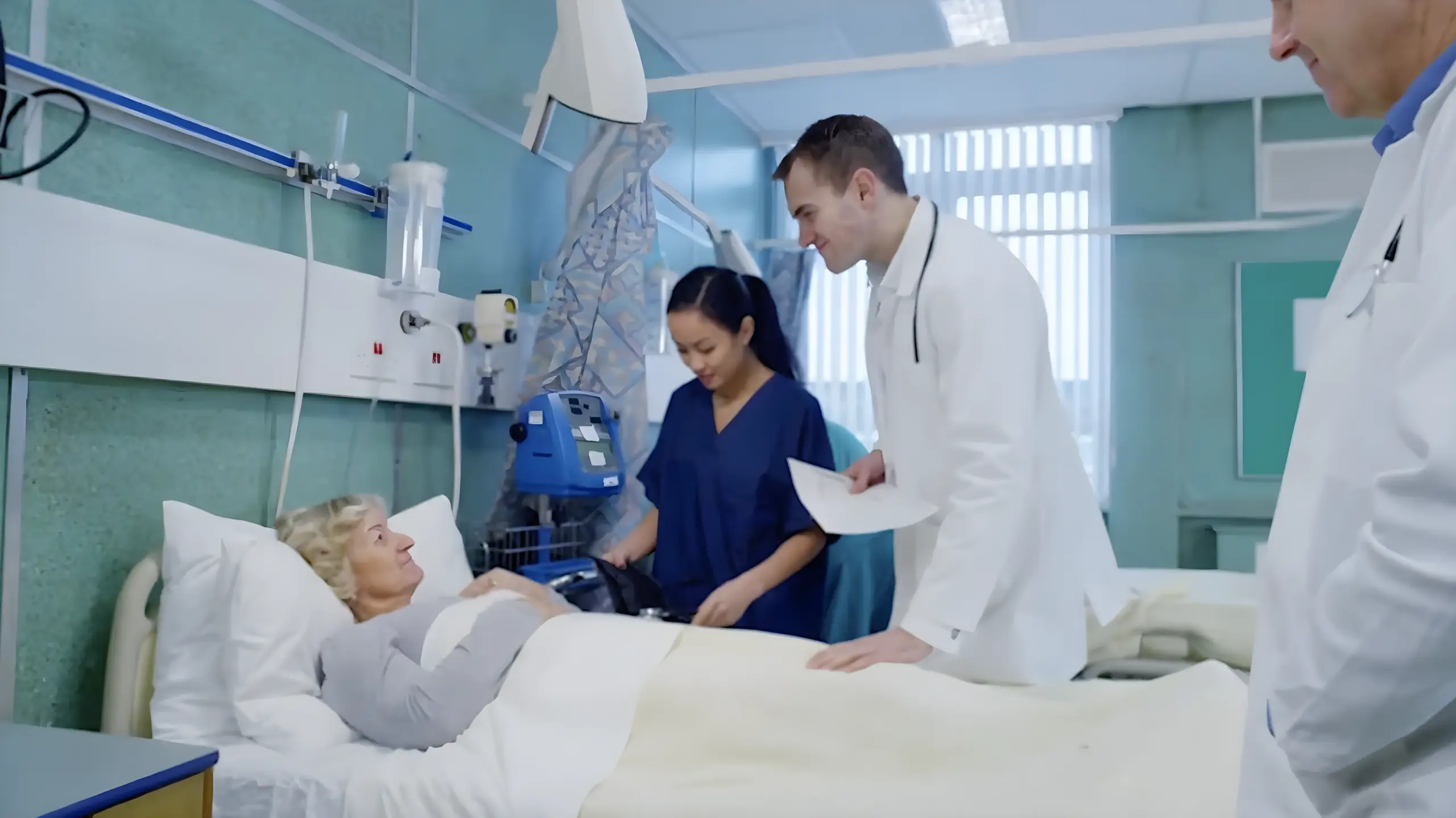 A smiling doctor and nurse stand by a hospital bed, where an elderly woman lies comfortably covered with a blanket. The scene conveys care and professionalism.