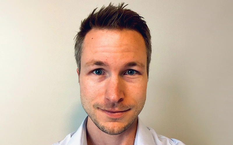Professional headshot of Matthew Traylor, wearing a dark suit and a light-colored tie.