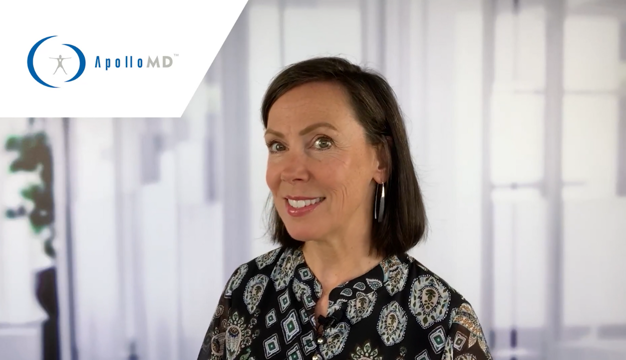 A warm, professional portrait of professional. She has short brown hair, is wearing a blouse, and is smiling directly at the camera against a bright backdrop