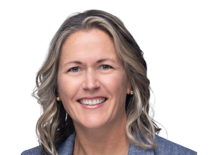 Jen Goldbach with wavy, shoulder-length blonde hair, wearing a blue blazer. She is facing the camera against a plain white background.